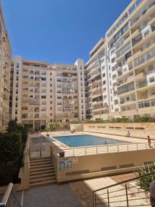 a large apartment building with a large swimming pool at Anis Home in Agadir