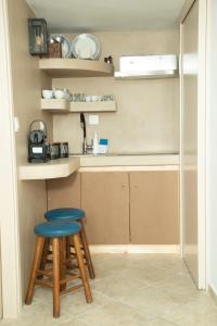 a small kitchen with a stool and a counter at Giacomo Tinos, Cozy Maisonette in Tinos Town in Tinos Town