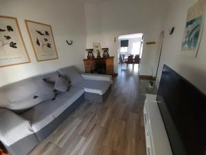 a living room with a couch and a flat screen tv at Casa no Campo in Algoz