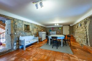 eine Küche und ein Esszimmer mit einer Steinmauer in der Unterkunft Casa das Pintoras Garden and Pool in Vila Praia de Âncora