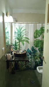 a bathroom with a shower curtain with plants on it at Casa Olivos in Olivos +26 photos