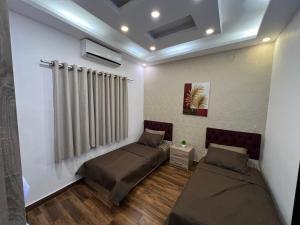 a room with two beds and a radiator at Jordan Chalet in Ath Thughrah