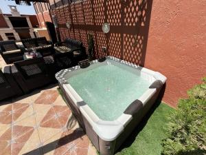 a hot tub sitting on the grass next to a building at Jordan Chalet in Ath Thughrah