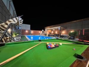 a pool table with pool balls and cuesticks on it at Jordan Chalet in Ath Thughrah