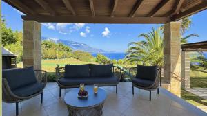 a patio with two chairs and a table with drinks on it at Villa Dimitra in Trapezaki