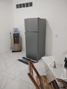 a kitchen with a refrigerator and a table and a chair at Cantinho especial de Piedade in Recife