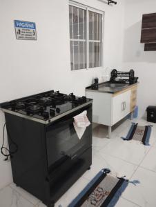 a kitchen with a black stove and a sink at Cantinho especial de Piedade in Recife