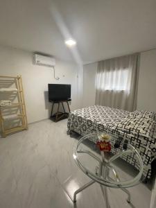 a room with a bed and a table in it at Casa Aconchegante Bem Localizada in Natal