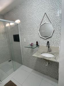 a bathroom with a sink and a shower with a mirror at Casa Aconchegante Bem Localizada in Natal +11 photos