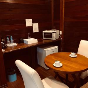 uma cozinha com uma mesa e um micro-ondas em Pousada dos Quatis em Campos de Jordão
