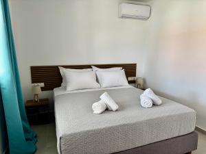 a bedroom with a bed with two towels on it at Massalia Suites Villa Vita in Agios Stefanos