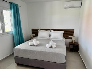 a bedroom with a bed with two towels on it at Massalia Suites Villa Vita in Agios Stefanos +2 photos