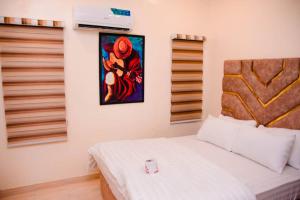 una camera da letto con un letto e un dipinto sul muro di Ddk Apartment a Oko Erin