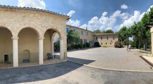 two people walking in a courtyard of a building at Studio des Anges #2 in Sauve
