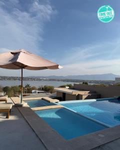 ein Swimmingpool mit Sonnenschirm und Tisch und Sonnenschirm in der Unterkunft Time Out Vacations in Vidalrstn