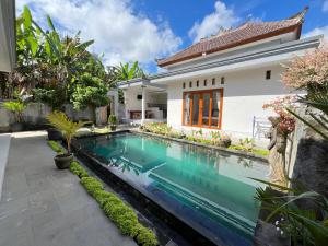 a swimming pool in front of a house at D Teba Ubud Villa in Ubud