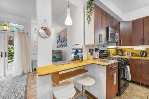 バークレーにある#Urban Elegance 3BR With Parking Near UC BART & Downtownのキッチン(木製キャビネット付)、カウンター(スツール付)