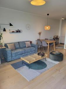 a living room with a blue couch and a table at Valgre Residence 7th Floor in Pärnu