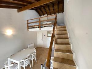 a room with a table and a staircase with a table and chairs at Brisa Marina Apart Hotel in Pinamar