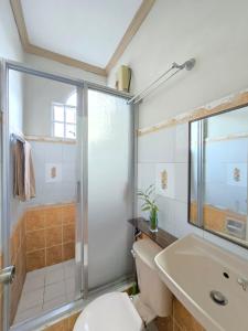 a bathroom with a shower and a toilet and a sink at 35 Amistad Guesthouse in Baguio +42 photos