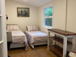 MyocumにあるThe Saddle Road Farmhouseのベッドとテーブルと窓のある部屋