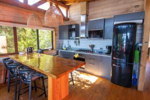 a kitchen with a wooden table and a black refrigerator at Morros del Pacífico in Chacurra
