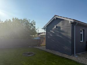 a small black shed sitting in a yard at Le petit Chalet in La Ferté-Saint-Aubin