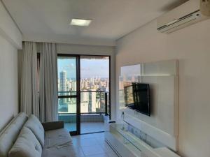a living room with a couch and a flat screen tv at Flat Rosarinho Essence in Recife