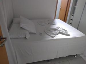 a white bed with a pair of gloves on it at Flat Rosarinho Essence in Recife +7 photos