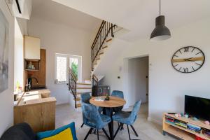 een woonkamer met een tafel, stoelen en een klok bij Apartments Kralj Ana in Cavtat