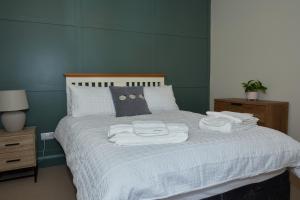 a bedroom with a bed with towels on it at No32 Carmarthen Road in Llandeilo
