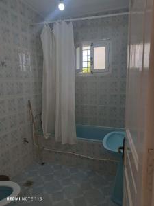 ein Badezimmer mit Duschvorhang und Badewanne in der Unterkunft Moha in Kelibia