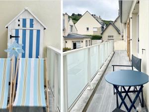a balcony with a blue table and a white fence at Fenêtre sur Mer I CAP MER in Port-en-Bessin-Huppain +57 photos