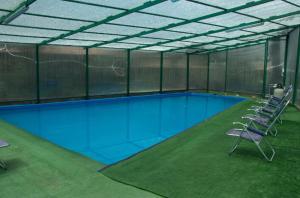 a large swimming pool with chairs in a building at Illa Wasi Sacred Valley in Urubamba