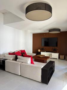 Una sala de estar con un sofá y un televisor de pantalla plana. en Villa cala tarida, en Cala Tarida