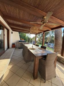 Un patio con una mesa y sillas de madera. en Villa cala tarida, en Cala Tarida