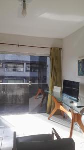 卡波布里奥Lindo apartamento de frente a praia do forte cabo frio的客厅设有玻璃桌和窗户