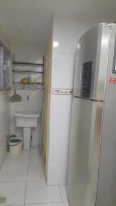 卡波布里奥Lindo apartamento de frente a praia do forte cabo frio的白色的厨房配有冰箱和水槽 更多26张照片