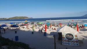 卡波布里奥Lindo apartamento de frente a praia do forte cabo frio的海滩上一群人拿着遮阳伞