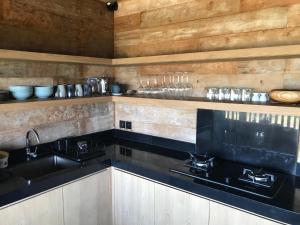 a kitchen with black counters and a sink at Cliff House Balian in Balian