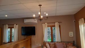 a living room with a tv and some windows at Loft 35 metros cuadrados in Mar de las Pampas