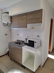 Una pequeña cocina con fregadero y microondas. en Depto moderno en pleno centro, en Rosario