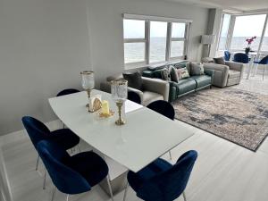 a living room with a white table and blue chairs at Ocean Front on Fort Lauderdale Beach 2 br Condo Apartment in Fort Lauderdale
