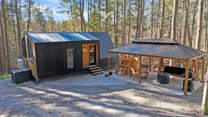 WiscassetTiny A-Frame Romantic Getaway的树林里有一间带凉亭的小木屋