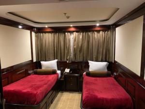 カイロにあるnile cruise river boatのベッドが2つと窓がある小さな部屋