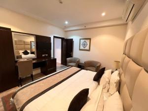 a bedroom with a large bed and a desk in it at Alshaheen Suites in Jeddah +64 photos