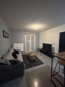 a living room with a couch and a flat screen tv at Appartement chaleureux Bordeaux in Villenave-dʼOrnon