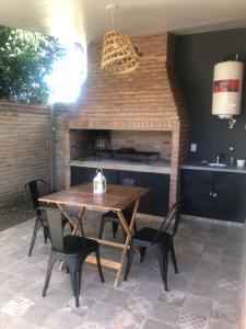 een tafel en stoelen in een keuken met een open haard bij Quinta Mi Quincho in San Pedro +3 foto's