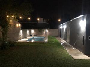 een achtertuin 's nachts met een zwembad bij Quinta Mi Quincho in San Pedro