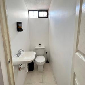 a white bathroom with a toilet and a sink at Casa en Tehuacán Se puede facturar in Cedro +14 photos